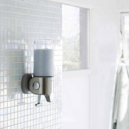 Angled view of Simplehuman Single Wall Mount Pump in Brushed Stainless Steel, space-saving shower dispenser
