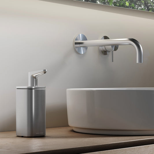 Simplehuman 10 oz. Pulse Pump in Brushed Stainless Steel beside a vessel sink in a modern bathroom.