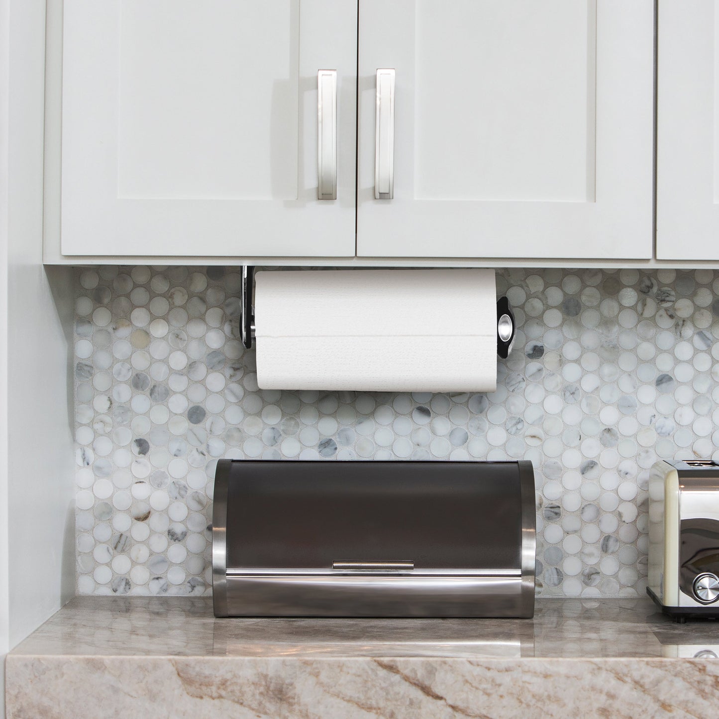 Lifestyle shot of Simplehuman Polished Stainless Steel Quick-Load Paper Towel Holder under kitchen cabinets.