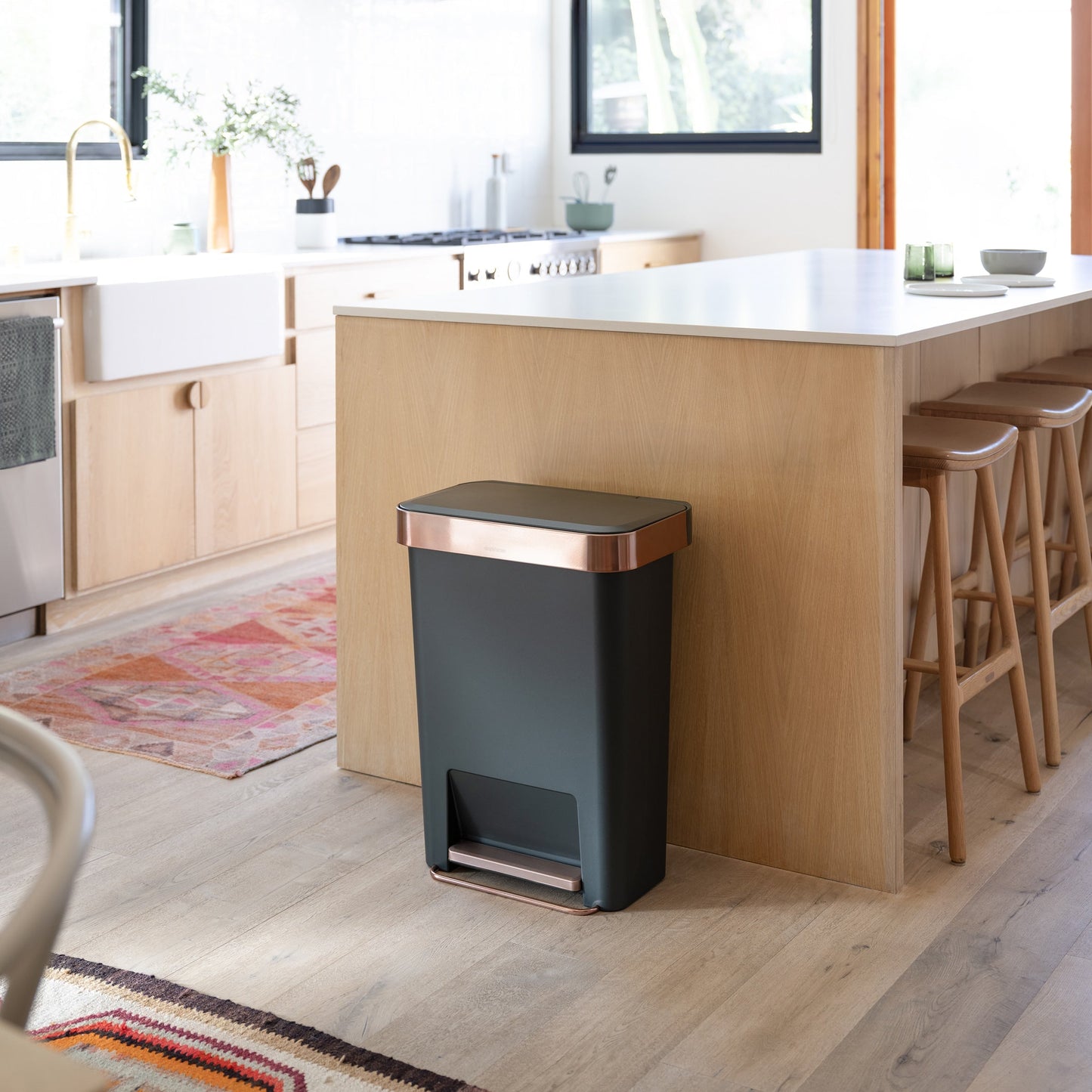 Simplehuman 45L Hybrid Step Can, Dark Green with Rose Gold, hands-free in a modern kitchen setting.