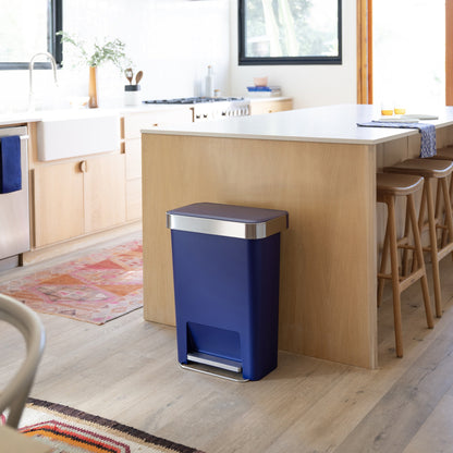 Simplehuman 45L Hybrid Step Can, Ultra Violet, hands-free pedal, resting against a light wood kitchen island.