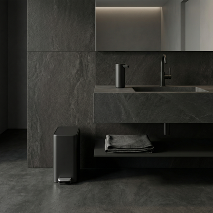 Simplehuman's 5L Slim Step Can in Matte Black in a modern, darker bathroom setting with black tiles and flooring complimented with the Simplehuman Sensor Pump in Matte Black.