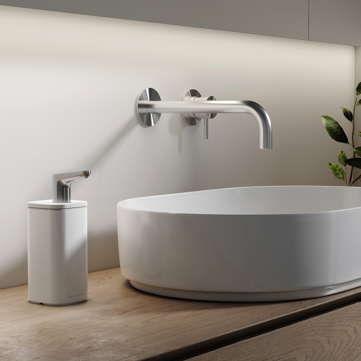 Simplehuman 10 oz. White Pulse Pump on wood counter beside vessel sink, ergonomic stainless steel spout.