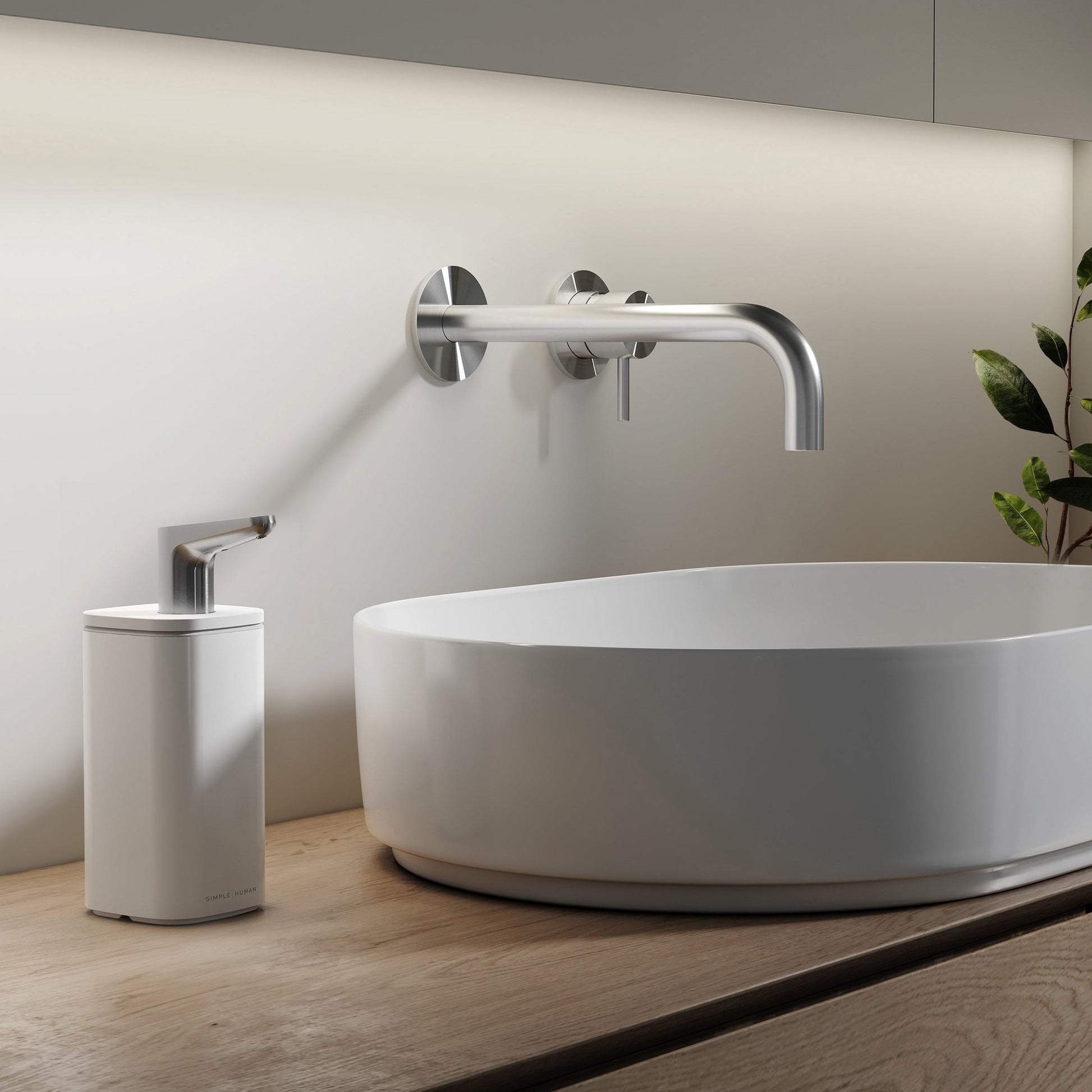 Simplehuman 10 oz. White Pulse Pump on wood counter beside vessel sink, ergonomic stainless steel spout.