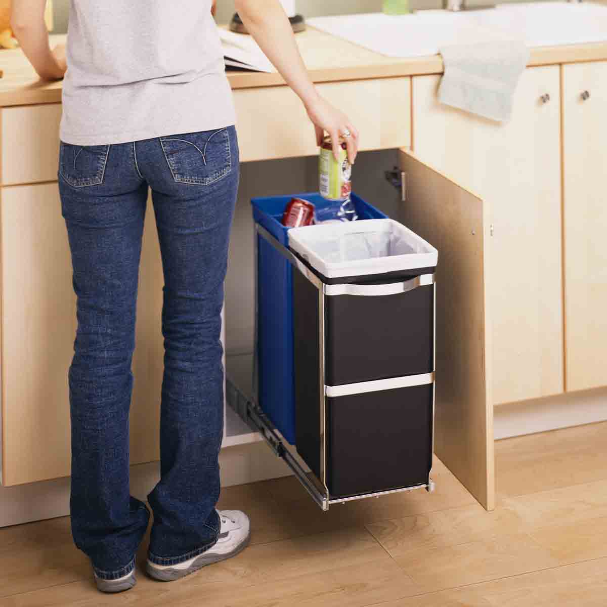 Simplehuman 35L Dual Compartment Pull-Out Can, Polished Steel, shown in use for trash and recycling under kitchen counter.