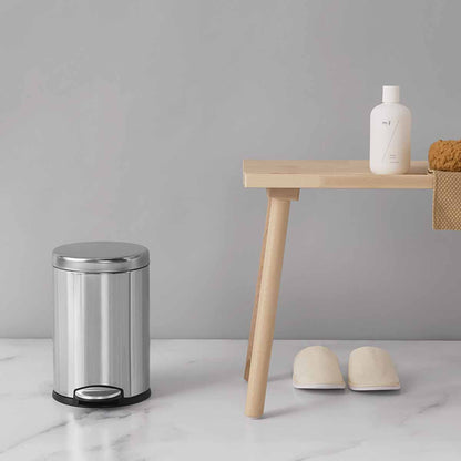 Lifestyle view of Simplehuman 4.5L Round Step Can, Brushed Stainless Steel, small size for bathroom use, hands-free pedal.