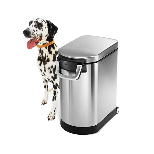 Angled view of Simplehuman Medium Pet Food Can, Brushed Stainless Steel, airtight locking handle, shown with dog.