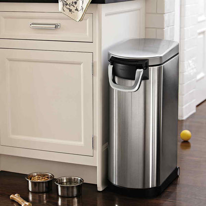 Simplehuman X-Large Pet Food Can, Brushed Stainless Steel, shown closed next to pet bowls for airtight storage in the kitchen.