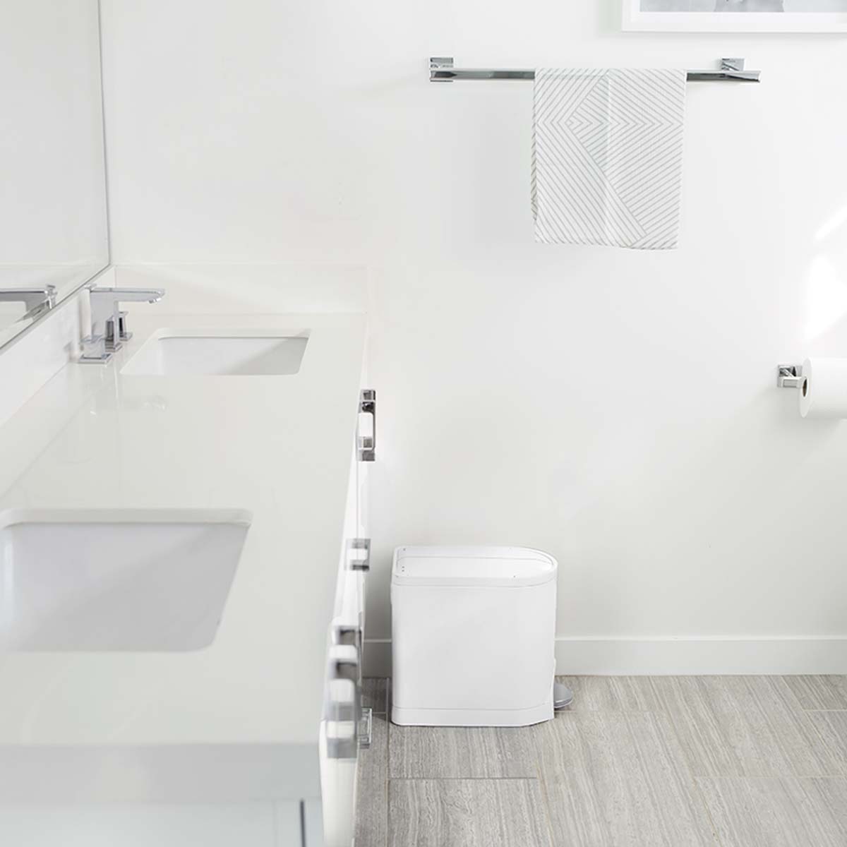 Simplehuman White 10L Butterfly Step Can in modern bathroom, narrow fit beside vanity, hands-free pedal.