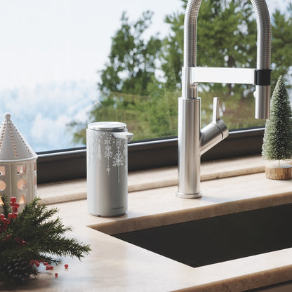 Simplehuman 14 oz. Sensor Pump with silver Holiday Sleeve in festive kitchen setting, touch-free operation.