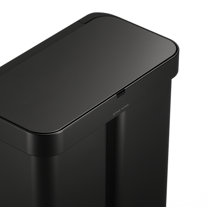Detail view of Simplehuman Matte Black 58L Sensor Recycler lid, highlighting the logo and touch-free sensor area.